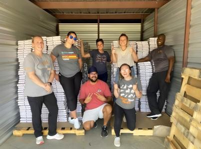 Group of people in an enclosure with pallets of pet food